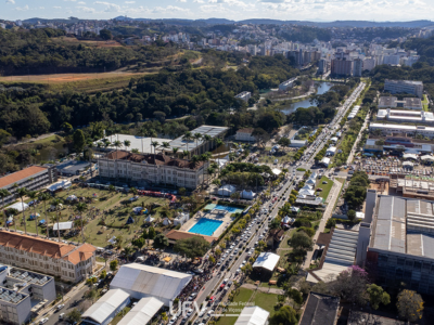 Foto aérea do campus, com muitas tendas e grande movimentação de carros e pessoas. Ao fundo, centenas de prédios. 