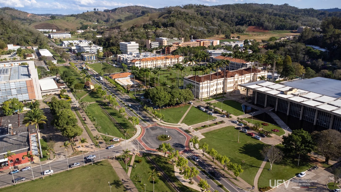 Foto aérea departe do campus, com dezenas de prédios diferentes e grandes gramados entre eles. 