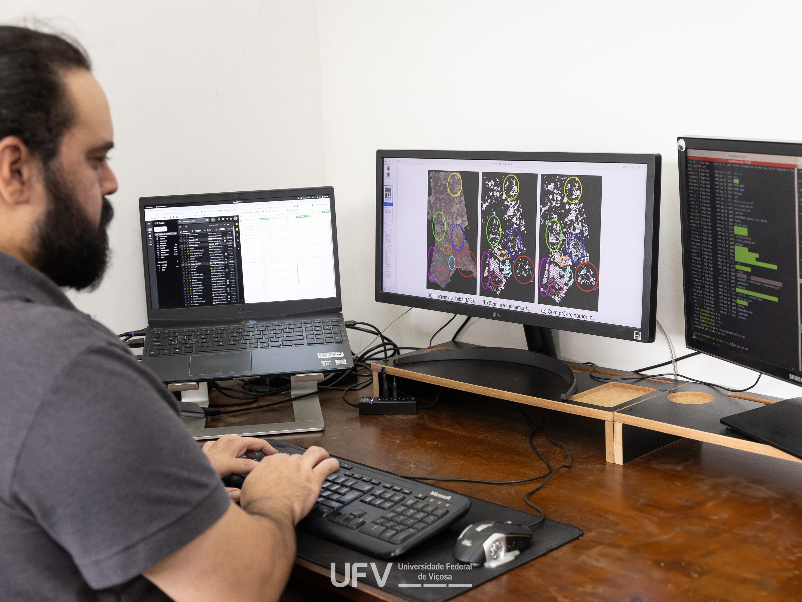 Homem de pele clara, cabelos pretos presos, barba e bigode pretos, digita num teclado. 