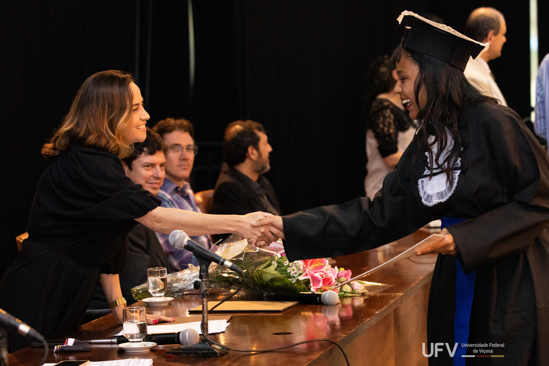 Vice-reitoria cumprimenta pós-graduanda durante a cerimônia. 