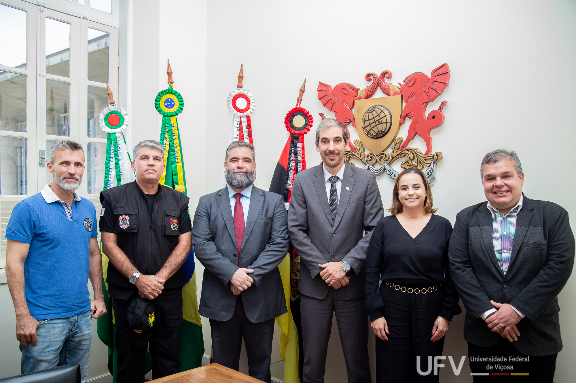 Na ordem: Vladimir, Lúcio Mauro, Carlos Henrique, Demetrius, Rejane e Marcelo em frente ao brasão da UFV. 