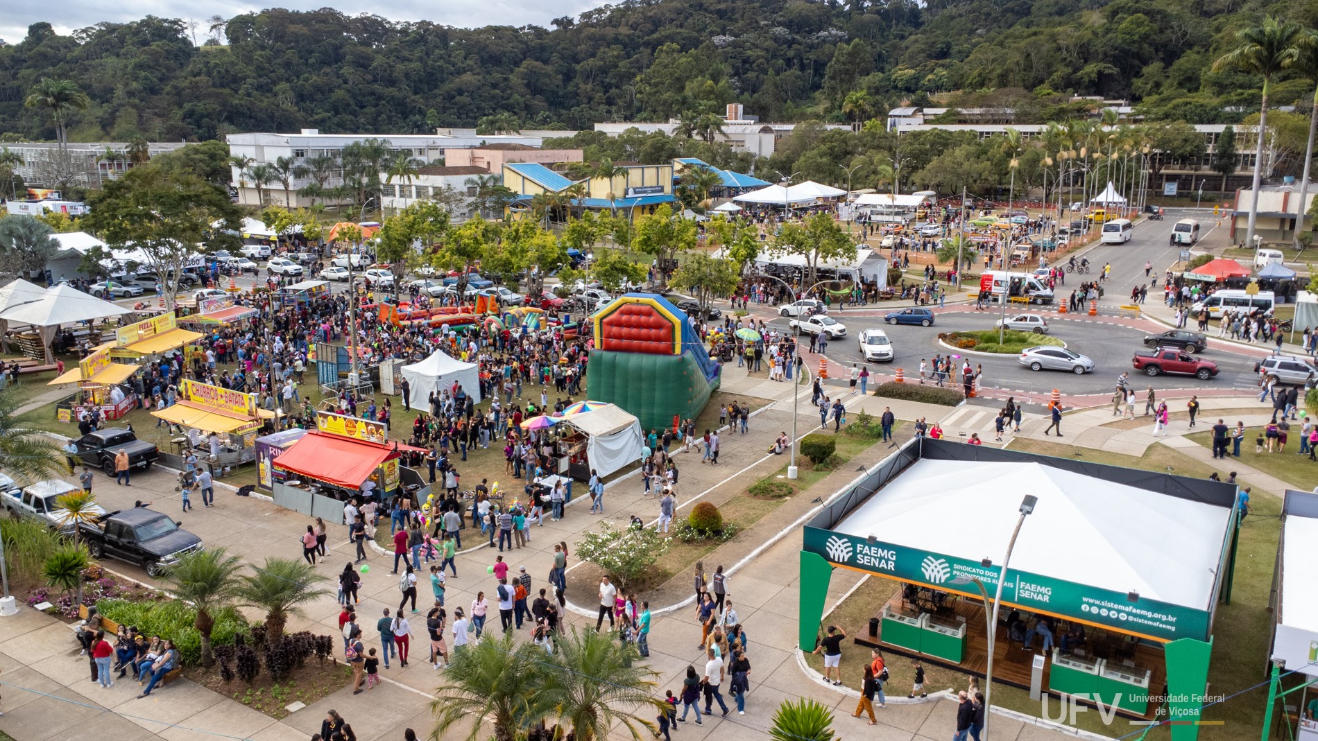 Foto aérea de parte da área com stands do evento. Vê-se grande número de pessoas circulando pelo local. 