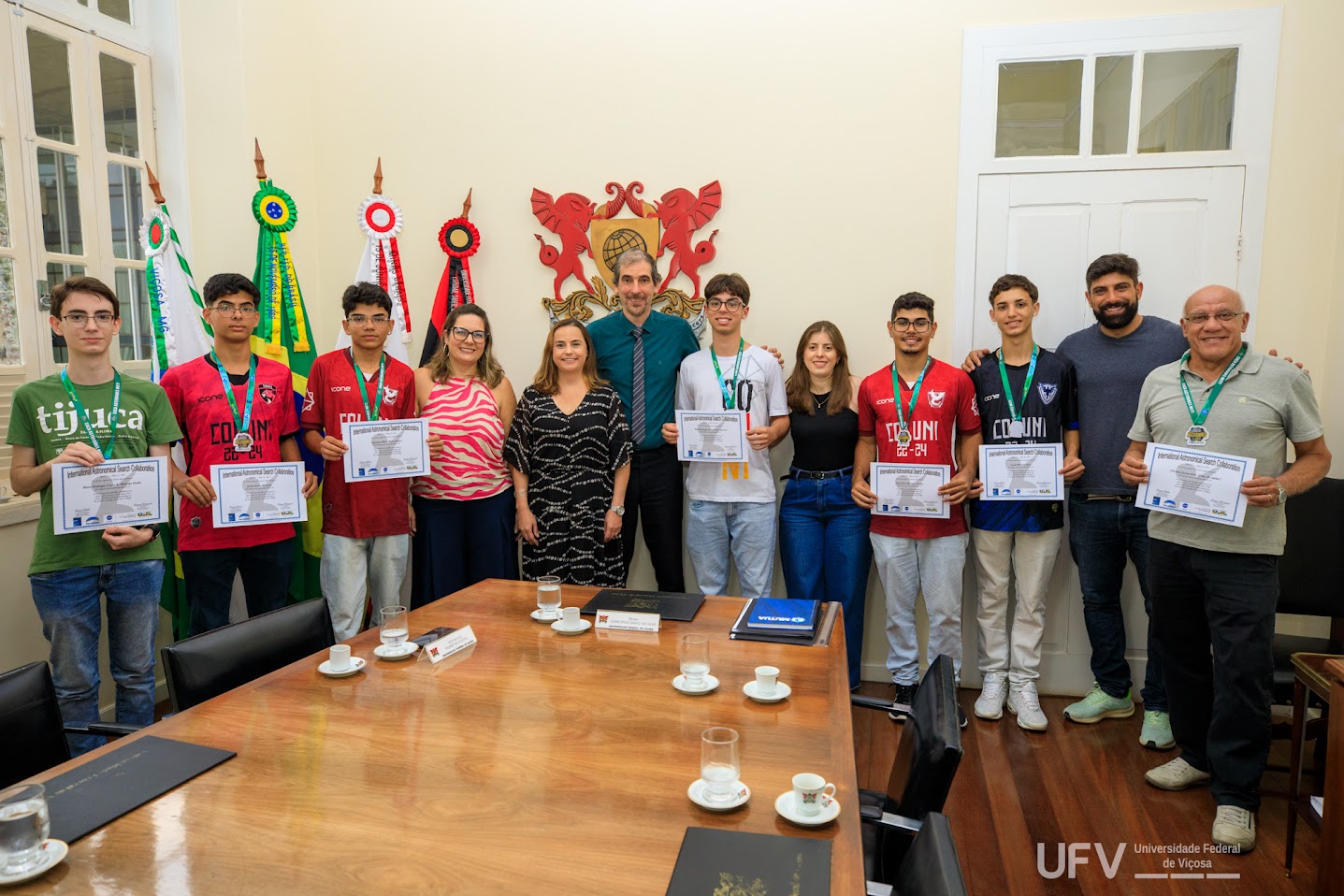 Foto dos estudantes premiados, seus professores, o reitor e a vice-reitora (ao centro), com seus certificados e medalhas. 
