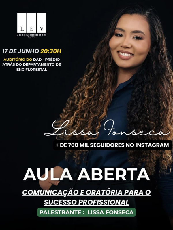 Mulher parda, olhos levemente puxados, cabelos longos pretos ondulados, maçãs do rosto proeminentes. Ela sorri. 